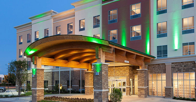 a large hotel with a lit up entrance. houston live surveillance