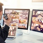 a man sitting in front of two computer monitors.