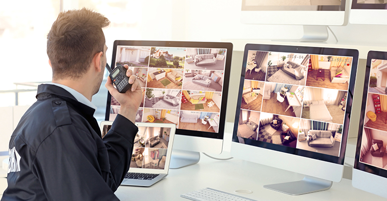 a man sitting in front of two computer monitors.